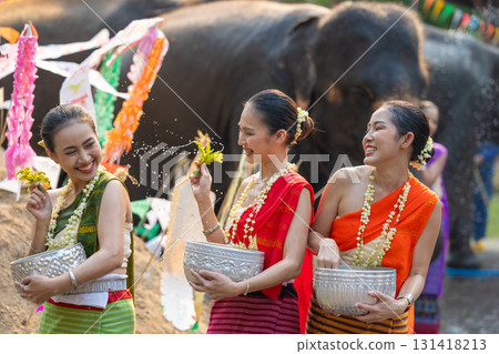 Songkran festival. Northern Thai people in Traditional clothes dressing splashing water together in Songkran day cultural festival with elephant background. 131418213