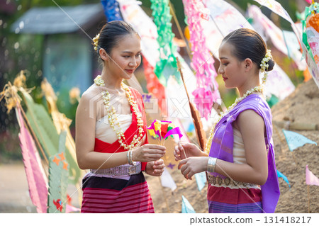 Songkran festival. Northern Thai people in Traditional clothes dressing carrying sand into temple to build sand pagoda and decoration with colorful paper flag. 131418217
