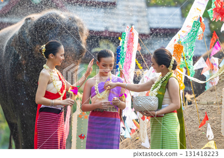 Songkran festival. Northern Thai people in Traditional clothes dressing splashing water together in Songkran day cultural festival with elephant background. Songkran festival. Northern Thai people in Traditional clothes dressing splashing water together in Songkran day cultural festival with elephant background. 131418223