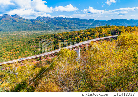 Hokkaido's Mikuni Pass: Matsumi Bridge and the Daisetsu Mountain Range, colored by autumn leaves 131418338