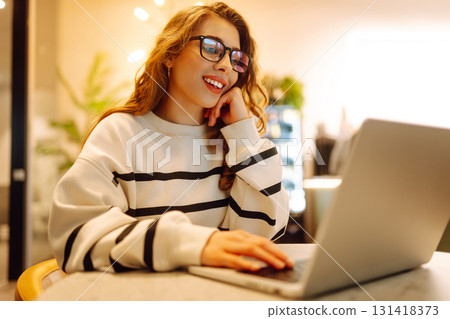 Young woman sitting on cafe with laptop. Beautiful college student on a cafe. Concept for education Young woman sitting on cafe with laptop. Beautiful college student on a cafe. Concept for education 131418373