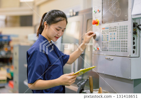 Engineer women control operate CNC industrial machine in metal production workshop. Asian young female industry worker. Engineer women control operate CNC industrial machine in metal production workshop. Asian young female industry worker. 131418651