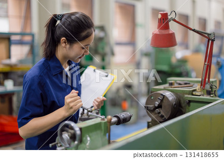 Asian women worker work in heavy industry with CNC lathe milling metal machine in steel product factory Asian women worker work in heavy industry with CNC lathe milling metal machine in steel product factory 131418655