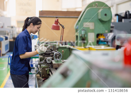 Asian women worker work in heavy industry with CNC lathe milling metal machine in steel product factory 131418656