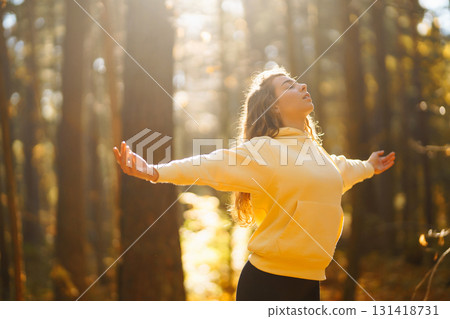 Beautiful woman practices yoga in the autumn forest. Lifestyle and meditation concept. Beautiful woman practices yoga in the autumn forest. Lifestyle and meditation concept. 131418731