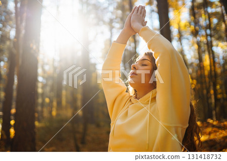 Beautiful woman practices yoga in the autumn forest. Lifestyle and meditation concept. Beautiful woman practices yoga in the autumn forest. Lifestyle and meditation concept. 131418732