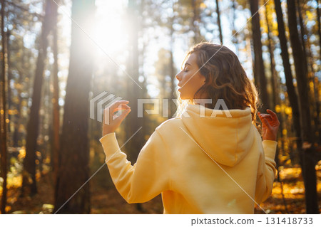 Beautiful woman practices yoga in the autumn forest. Lifestyle and meditation concept. Beautiful woman practices yoga in the autumn forest. Lifestyle and meditation concept. 131418733