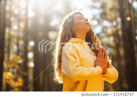 Beautiful woman practices yoga in the autumn forest. Lifestyle and meditation concept. 131418737