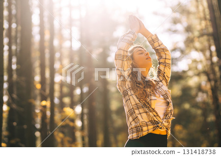 Beautiful woman practices yoga in the autumn forest. Lifestyle and meditation concept. Beautiful woman practices yoga in the autumn forest. Lifestyle and meditation concept. 131418738
