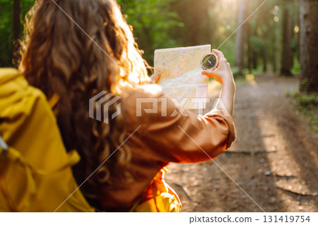 Exploring the forest with a map and compass during a sunny afternoon in a tranquil wooded area Exploring the forest with a map and compass during a sunny afternoon in a tranquil wooded area 131419754