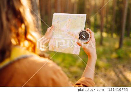 Exploring the forest with a map and compass during a sunny afternoon in a tranquil wooded area 131419763