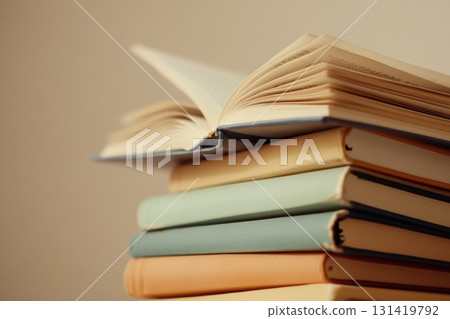 A stack of old books with soft pastel covers. Minimalistic background. This is a perfect image for bookstores, publishing houses, magazines about culture, education, self-development. Copyspace 131419792