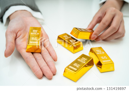Asian woman holding gold bar in finance business. Asian woman holding gold bar in finance business. 131419897