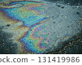 Oil spill creating colorful iridescent rainbow on asphalt 131419986