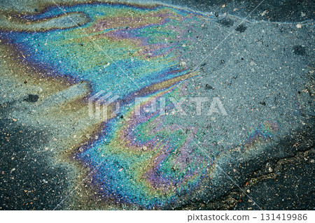 Oil spill creating colorful iridescent rainbow on asphalt 131419986