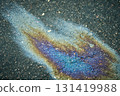 Oil slick on wet asphalt showing vibrant iridescent colors and pollution concept. 131419988