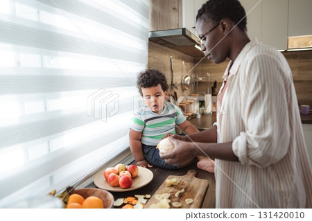 Mother and child preparing healthy fruit snack in kitchen Mother and child preparing healthy fruit snack in kitchen 131420010