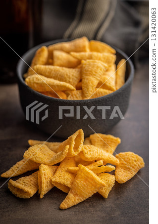 Bugles snack. Cone corn chips on kitchen table. 131420063