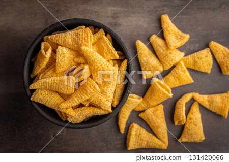 Bugles snack. Cone corn chips in bowl on kitchen table. Top view. Bugles snack. Cone corn chips in bowl on kitchen table. Top view. 131420066