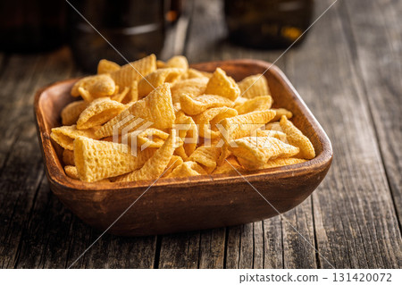 Bugles snack. Cone corn chips in bowl on wooden table. Bugles snack. Cone corn chips in bowl on wooden table. 131420072