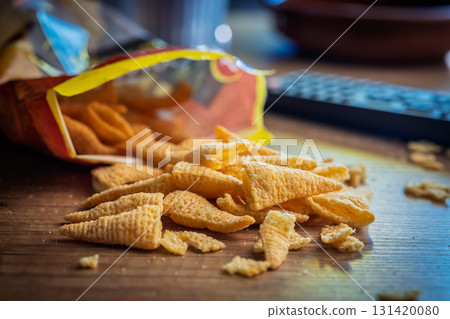 Bugles snack. Cone corn chips on wooden table. 131420080