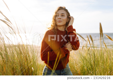 Happy woman enjoying nature outdoors in tall grass. Flying hairs. Outdoor. Fashion style. Happy woman enjoying nature outdoors in tall grass. Flying hairs. Outdoor. Fashion style. 131420216