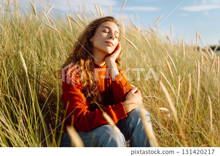 Happy woman enjoying nature outdoors in tall grass. Flying hairs. Outdoor. Fashion style. Happy woman enjoying nature outdoors in tall grass. Flying hairs. Outdoor. Fashion style. 131420217