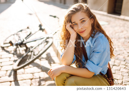 Beautiful smiling woman sitting next to bike on the street city. Adventure Concept Beautiful smiling woman sitting next to bike on the street city. Adventure Concept 131420643