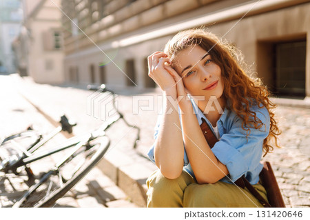Beautiful smiling woman sitting next to bike on the street city. Adventure Concept Beautiful smiling woman sitting next to bike on the street city. Adventure Concept 131420646