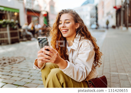 Happy woman with phone, text messaging on summer vacations on the street city. Lifestyle concept. 131420655