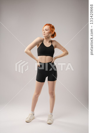 Elegant woman in black attire poses confidently with creative lighting Elegant woman in black attire poses confidently with creative lighting 131420668
