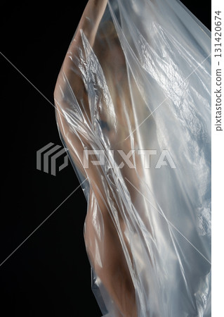 Elegant blonde woman poses in a studio with transparent fabric 131420674