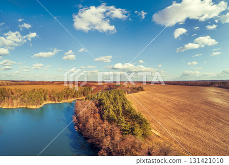 Lakeshore in autumn. View from above of  lake and arable field. Nature landscape Nature background 131421010