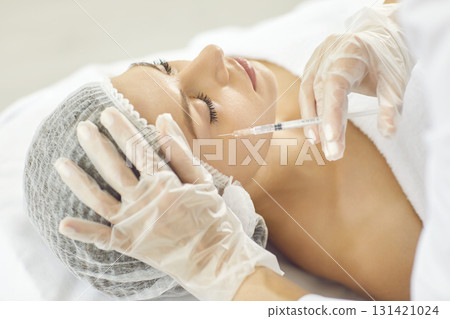 Woman is getting professional aesthetic injection done by cosmetologist at clinic 131421024