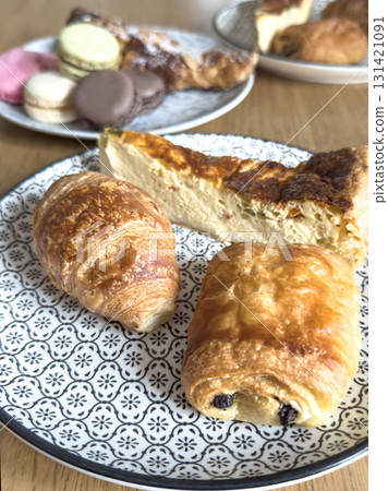 French Pastry Selection with Quiche, Croissant, Pain au Chocolat and Macarons Served on Elegant Plates French Pastry Selection with Quiche, Croissant, Pain au Chocolat and Macarons Served on Elegant Plates 131421091