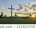 A large Christian cross in the scenery of a landscape. A Christian cross lighted by the setting sun. The concept of religion and Christianity. 131421550