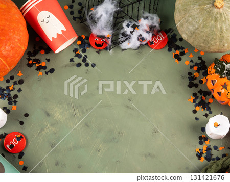 Halloween green frame background flatlay with pumpkins and party decor 131421676