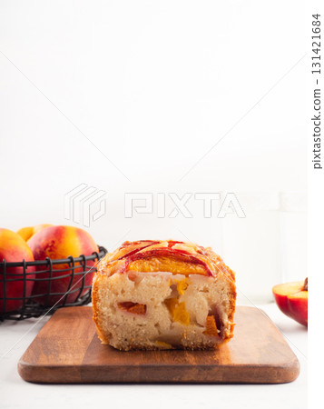 Peach cake loaf on wooden cutting board on white backgroud Peach cake loaf on wooden cutting board on white backgroud 131421684