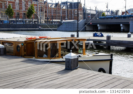 Tour Boat Docked by the Waterfront Near a Busy City Area in Amsterdam Tour Boat Docked by the Waterfront Near a Busy City Area in Amsterdam 131421950