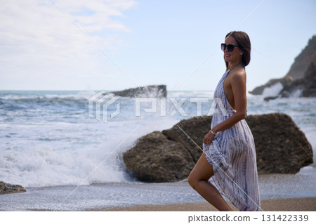 Stylish woman walking on seaside beach Stylish woman walking on seaside beach 131422339