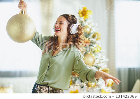 Joyful Woman Dancing with Headphones at Christmas 131422369