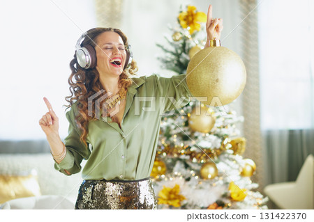 Mature Woman Dancing with Gold Christmas Ornament 131422370