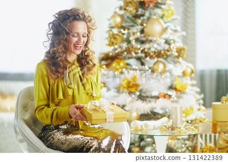 Woman with Yellow Blouse Unwrapping Christmas Gift Woman with Yellow Blouse Unwrapping Christmas Gift 131422389