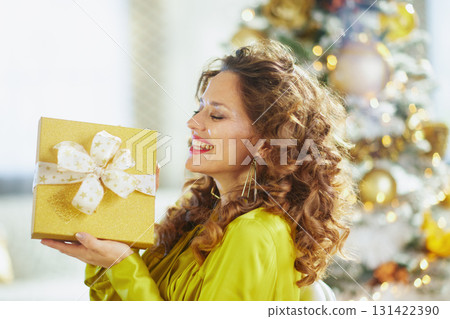 Pure Joy: Woman Celebrates Christmas with Golden Gift Pure Joy: Woman Celebrates Christmas with Golden Gift 131422390