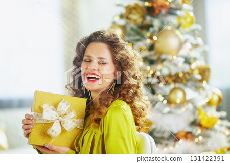 Laughing Woman with Golden Christmas Gift Laughing Woman with Golden Christmas Gift 131422391