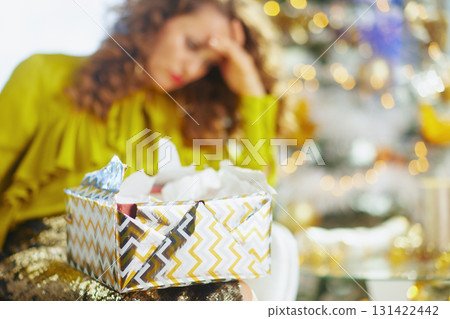 Overwhelmed Woman With Gift During Holiday Stress Overwhelmed Woman With Gift During Holiday Stress 131422442