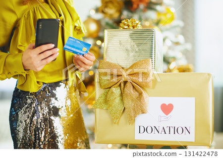 Woman Making Holiday Donation with Phone and Card 131422478