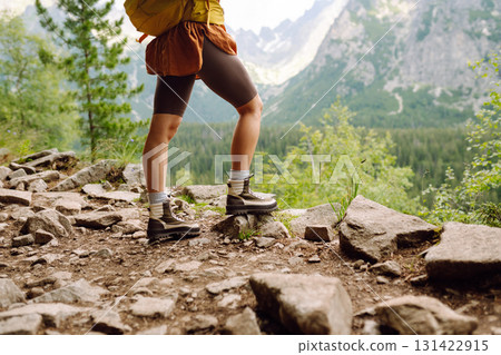 Female legs in hiking boots on hiking trail, on top of mountain outdoors. Nature, relaxation concept 131422915