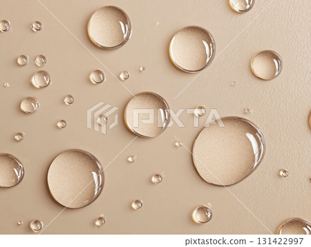 Texture of drops of serum or lotion with sparkling gold glitter on a beige background Texture of drops of serum or lotion with sparkling gold glitter on a beige background 131422997