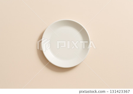 Empty white plate on soft beige background, minimalistic design, top view. Empty white plate on soft beige background, minimalistic design, top view. 131423367